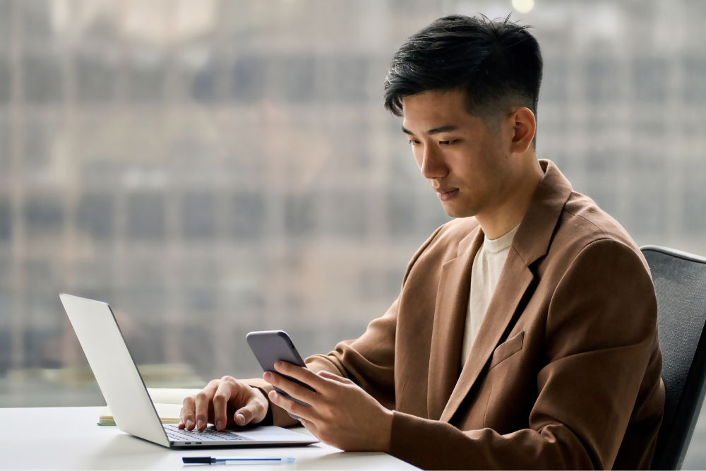 Professionista mentre usa un laptop e uno smarphone